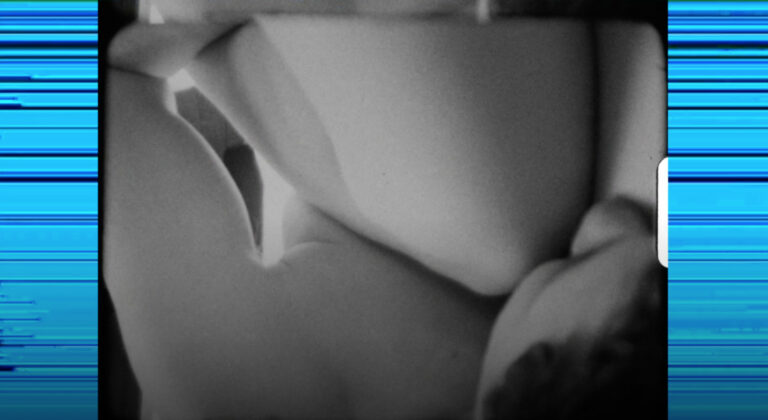 An close-up still image from black and white analgue footage of two women being intimate. The image is flanked on either side by bright blue lines