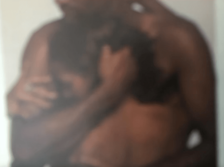 Blurred shot of an embrace between two people with dark skin.