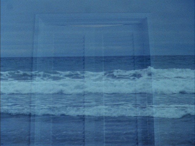 A dissolved shot of a closed door is layered over a blue seascape.